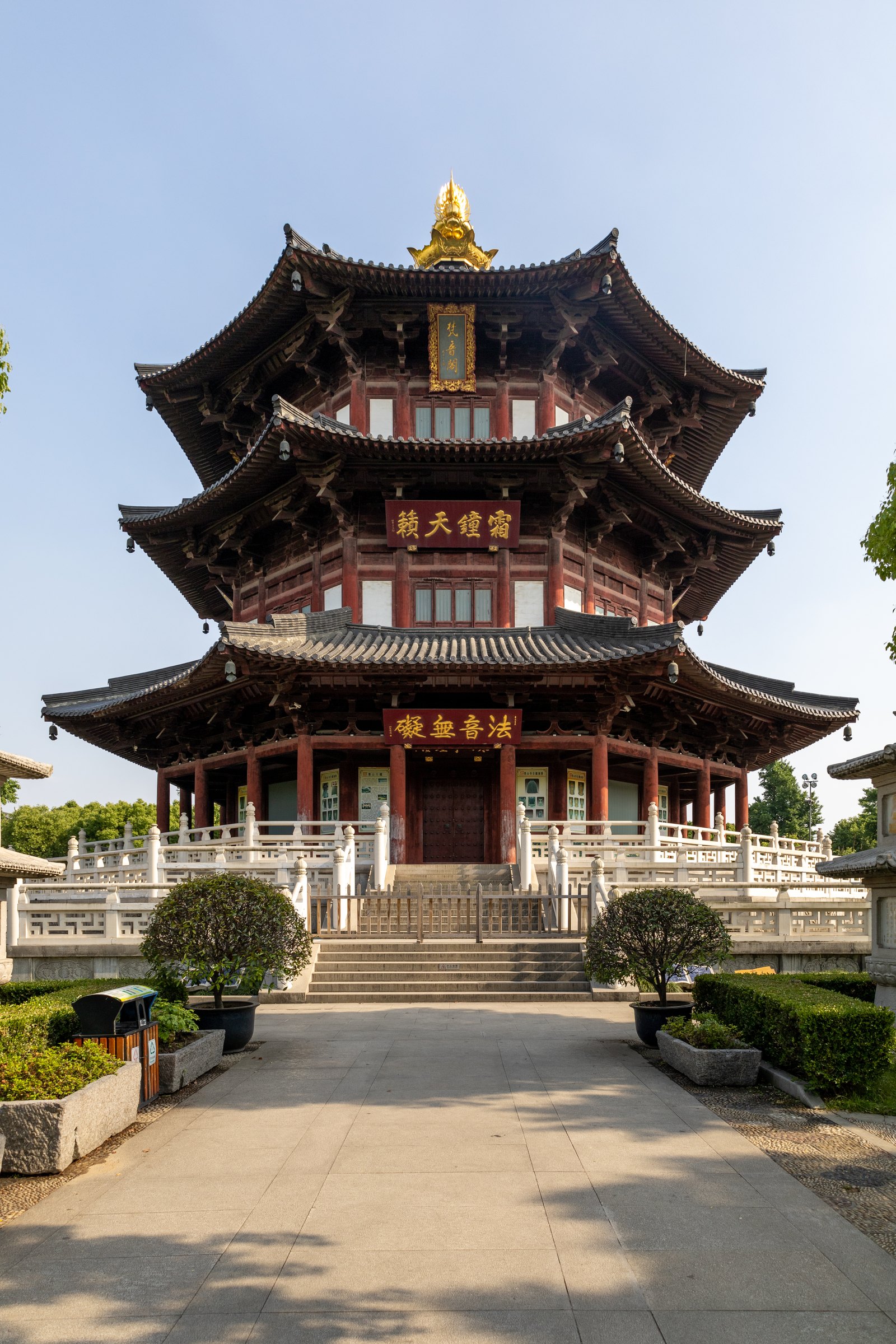 多层翘檐楼阁立在台阶尽头,红色木柱、白色栏杆与金色顶部装饰相映。